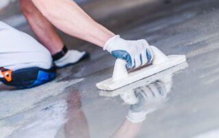 This image shows a man applying epoxy paint on the floor.